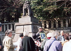 靖国神社の狛犬前で説明を聞く参加者
