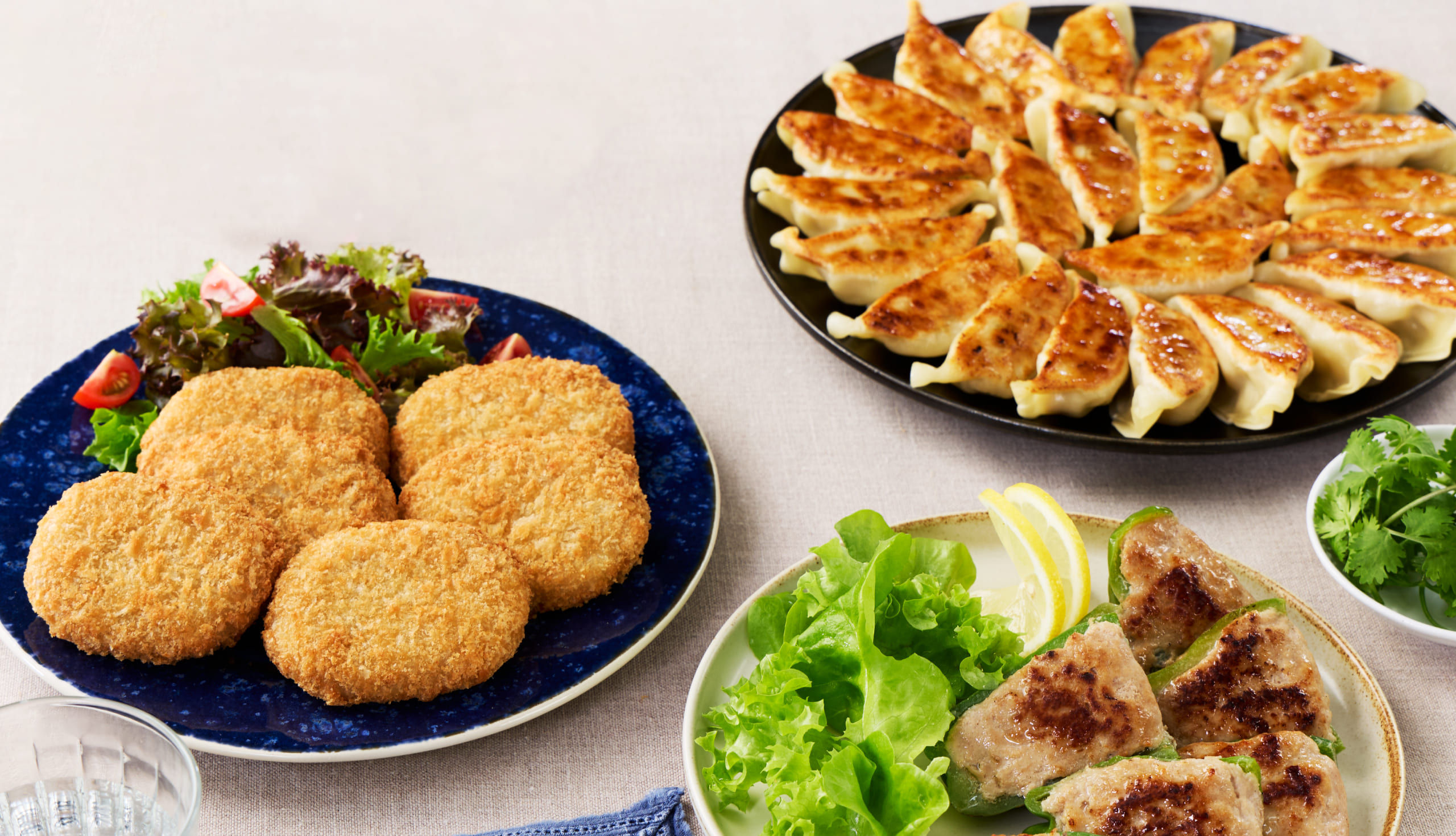 東都生協の産直冷凍総菜3点セット。東都肉餃子・東都ピーマン肉詰め・東都産直牛肉レンジコロッケを盛り付けた食卓